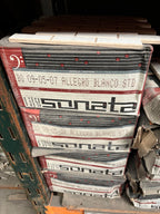 A stack of printed paper sheets or booklets labeled 'sonata' and 'Allegro Blanco Std' on a pallet in a warehouse-like setting.