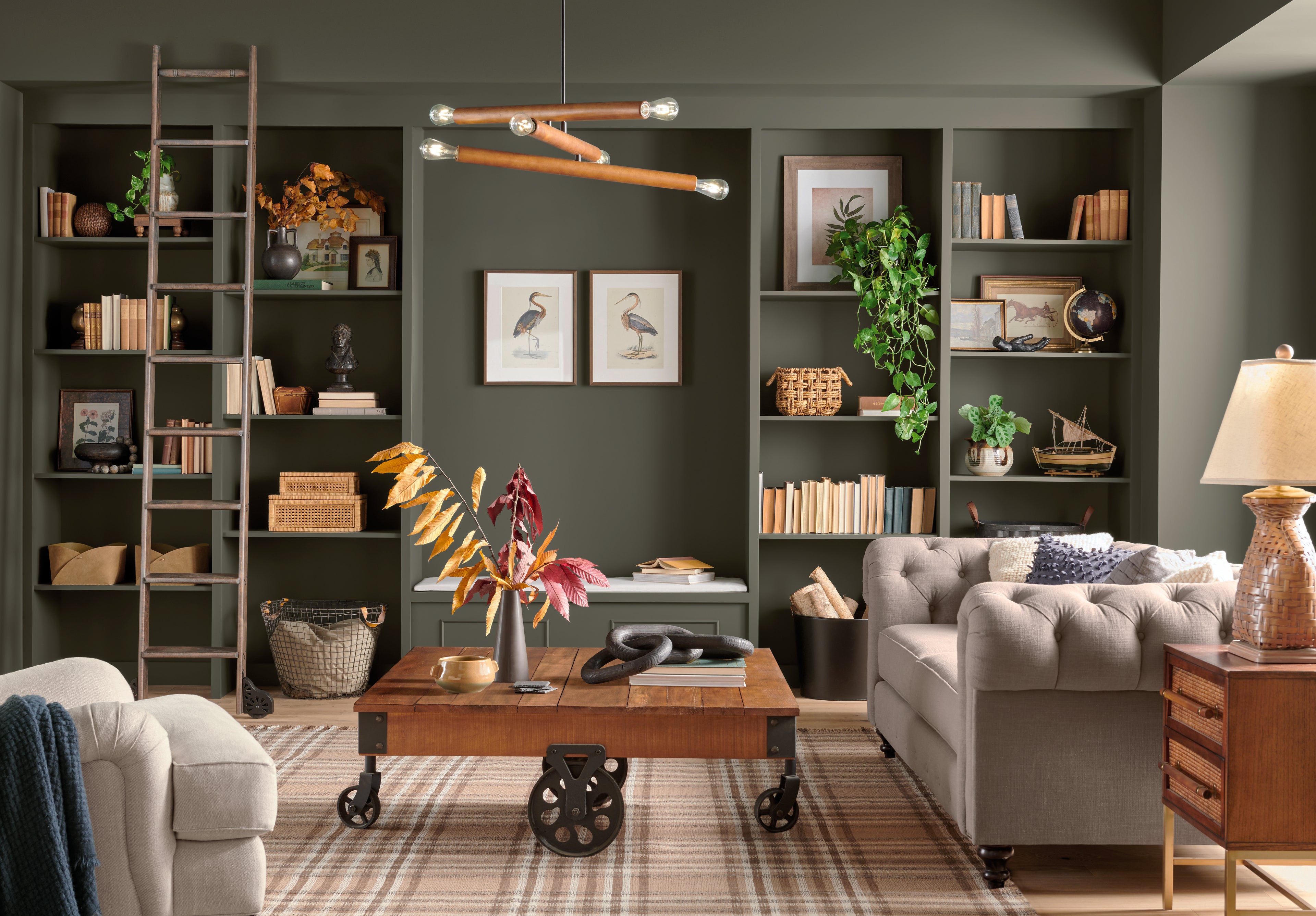 Modern living room with gray sofa, wooden coffee table, and bookshelves.