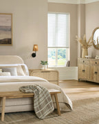 Neatly arranged bedroom with a bed, bench, and dresser.