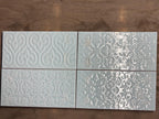 Four decorative tiles with embossed patterns
