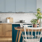 Modern kitchen with wooden and gray cabinets, a dining table, and plants.