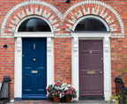 Two doors on a brick building, one blue and one purple, with decorative elements.
