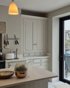 Modern kitchen with white cabinets, a countertop, and a door leading outside.