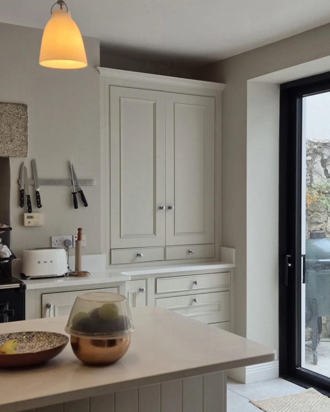 Modern kitchen with white cabinets, a countertop, and a door leading outside.