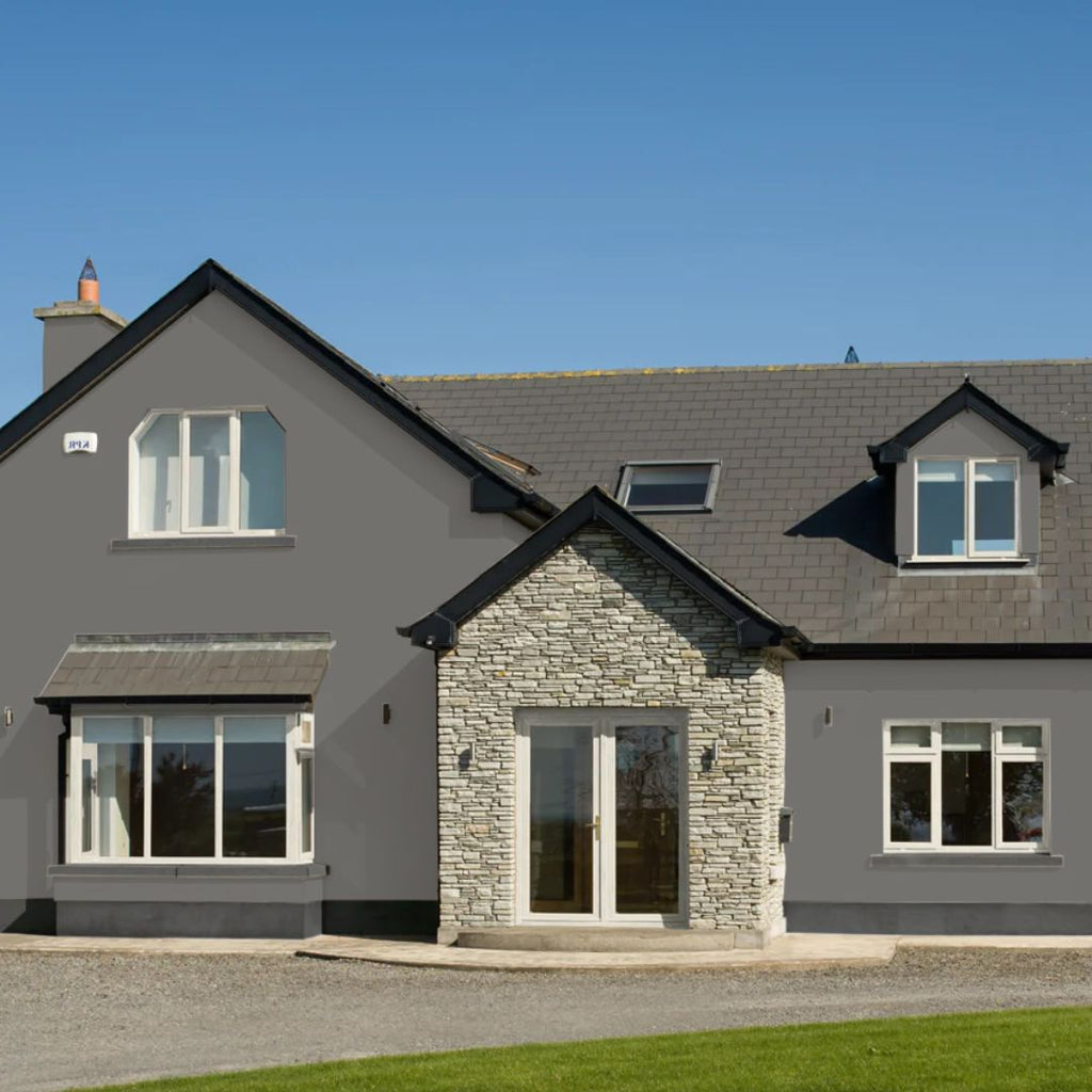 Gray house with stone entrance and green grass in front